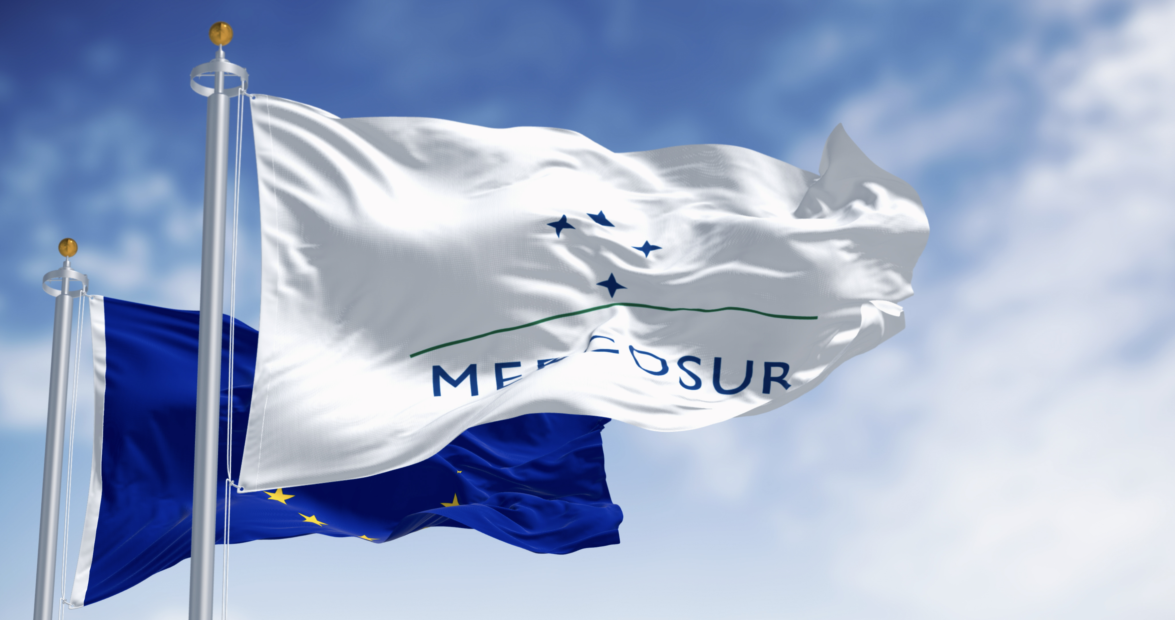 Flags of Mercosur and European Union waving in the wind on a clear day. International trading. Finance and economy. 3d illustration render. Selective focus